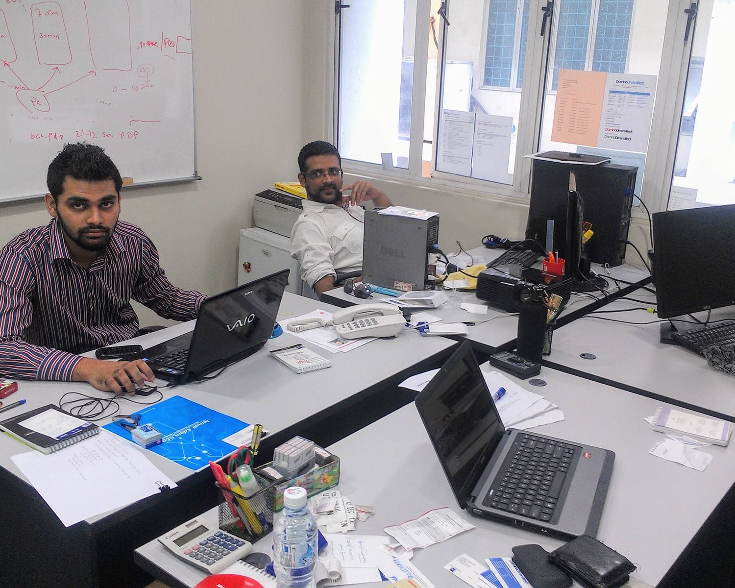 Naveed at a whiteboard with a colleague