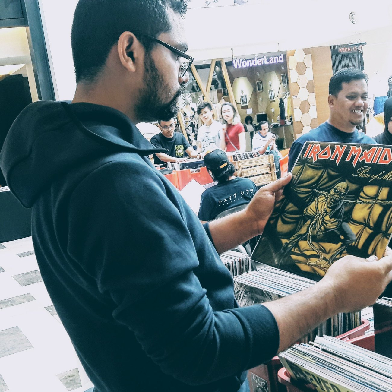 Naveed holding an Iron Maiden vinyl at a record fair