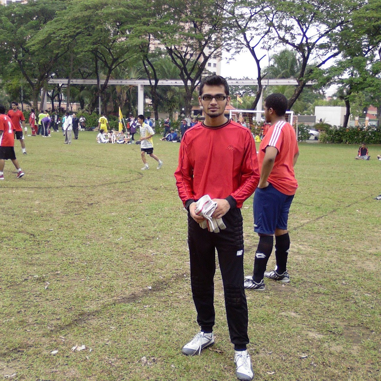 Naveed in goalkeeper gear on a football pitch in Malaysia